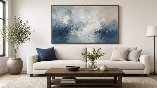 Large framed abstract artwork hung perfectly level and centered above a sofa