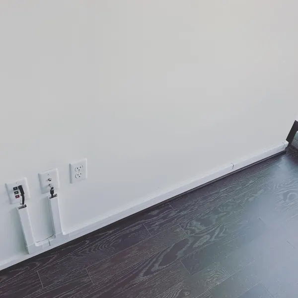 Clean cable management with paintable raceway along baseboard