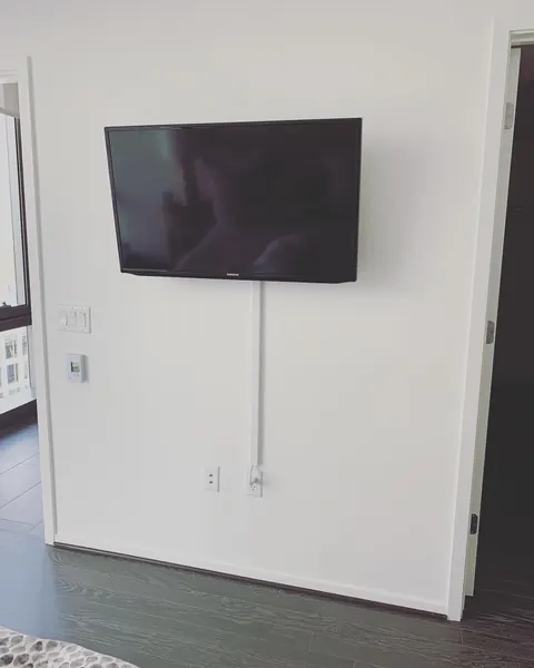 Bedroom TV mounting with a cord raceway painted to match the wall