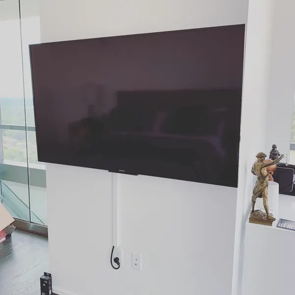 Professional TV mounting in a high-rise condo with concealed cord raceway
